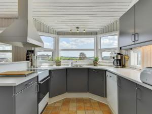 Una cocina con gabinetes grises y una ventana grande. en Spacious Retreat with Fjord View - By Traum Ferienwohnungen, en Egernsund