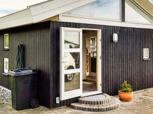a black house with a white door on it at Spacious Retreat with Fjord View - By Traum Ferienwohnungen in Egernsund