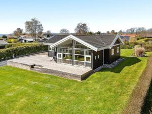 a house with a large deck in a yard at Spacious Retreat with Fjord View - By Traum Ferienwohnungen in Egernsund