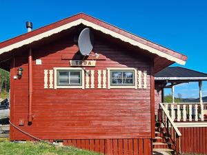 a red cabin with a sign on the side of it at 7 person holiday home in JARFJORD-By Traum in Karpbukt