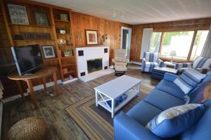 un soggiorno con un divano blu e un camino di North Shore Beach Retreat a Northport