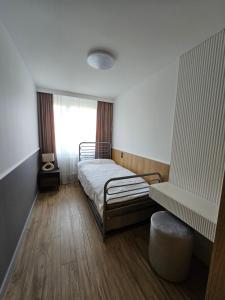 a bedroom with a bed and a window at Apartament Za fosą in Malbork