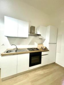 a kitchen with white cabinets and a sink at Piccola Dimora in Bitetto