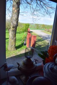 a window with a view of a tree and a fence at RUSTIC MAID´S ROOM in Lövestad