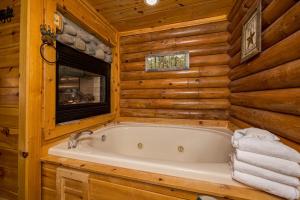 a bathroom with a tub in a log cabin at A Bears View in Glade +23 photos
