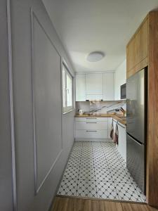 a kitchen with a door and a tile floor at Apartament Za fosą in Malbork