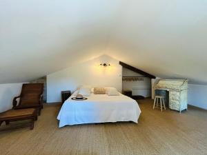 a attic bedroom with a bed and a piano at Le Clos des Pigières Gîte le Grènetier in Vaison-la-Romaine
