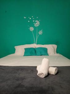 a bedroom with a bed with a green wall at MarJeri in Jericoacoara