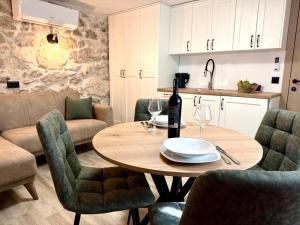 a table with a bottle of wine on it in a kitchen at Apartman Roza in Konjic