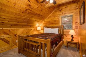 a bedroom with a bed in a log cabin at Absolutely Fabulous by American Patriot Getaways in Park Settlement +32 photos