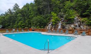 Una piscina con sillas y una cascada al fondo. en Absolutely Wonderful by American Patriot Getaways, en Henderson Springs