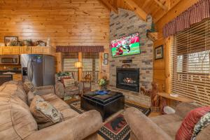 una sala de estar con sofá y TV en una cabaña en Absolutely Wonderful by American Patriot Getaways, en Henderson Springs