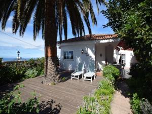a house with two chairs and a palm tree at Holiday Home Mesa del Mar near Black Beach in Tacoronte