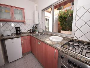 a kitchen with red cabinets and a sink and a stove at Holiday Home Mesa del Mar near Black Beach in Tacoronte