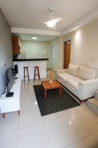 un salon avec un canapé blanc et une table dans l'établissement Casa Completa 01 com AR - Encantos de Arraial, à Arraial do Cabo