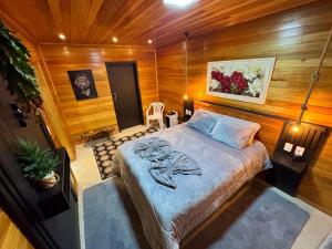 a bedroom with a bed in a room with wooden walls at Casa de Temporada Vó Laura in Urubici +2 photos