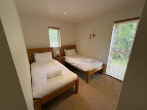 a bedroom with two beds and a window at Luxury Riverside Retreat In Picturesque Setting in Clunton