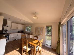 a kitchen and dining room with a table and chairs at Luxury Riverside Retreat In Picturesque Setting in Clunton