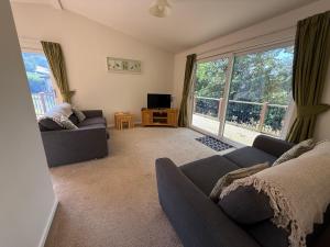 a living room with a couch and a tv at Luxury Riverside Retreat In Picturesque Setting in Clunton