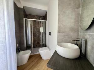 フォリーニョにあるFoligno City Roomsの浴槽、トイレ、洗面台を備えたバスルーム +9枚の写真