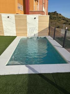una piscina con sedia e una casa di El Paraíso Del Rey a Ruidera