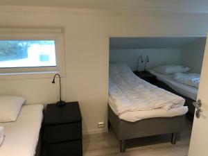Un dormitorio con dos camas y una ventana. en Bausje Beach , borhaug, en Farsund