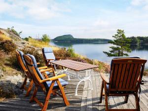 a table and chairs on a deck with a view of a lake at 6 person holiday home in HENÅN in Sundsandvik