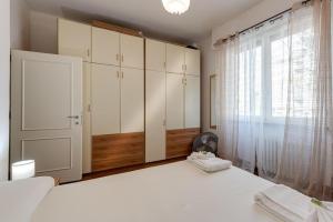 a bedroom with white cabinets and a large window at Apartment for 2 Florence Redi in Florence