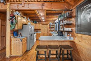 una cucina con pareti e sgabelli in legno di Bear Necessities by American Patriot Getaways a Line Spring