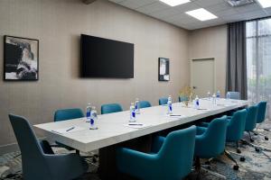 ein Konferenzraum mit einem langen Tisch und blauen Stühlen in der Unterkunft DoubleTree by Hilton Brunswick in Brunswick