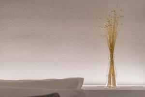 un jarrón con flores en él sentado en una mesa en Golden's Suite nel cuore di Modena, en Módena