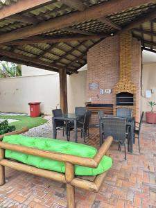 a patio with a table and chairs and a fireplace at Varandas do Mar pé na areia in Cumbuco
