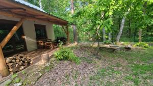 un porche de una casa con mesa de picnic y banco en Leśna Przystań, en Busko-Zdrój