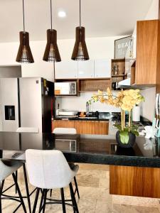 a kitchen with a black counter top and wooden cabinets at Bright Ocean View Studio with Rooftop Pool Access in Puerto Morelos +16 photos