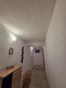 a hallway with a white wall with a light on it at Apartman u centru Komiže in Komiža