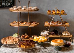 a display of different types of pastries on shelves at Hotel Golden Park Uberlandia By Nacional Inn in Uberlândia +44 photos