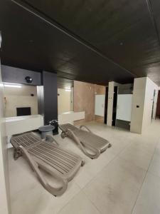 a bathroom with a row of benches and mirrors at Traugutta Angelcity GYM & SPA by BookingHost in Wrocław +11 photos