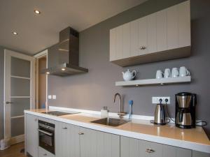 a kitchen with white cabinets and a sink at Apartment in Noordwijk near Beach in Noordwijk