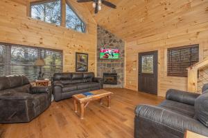 a living room with leather couches and a fireplace at Bessy Bears Cabin by American Patriot Getaways in Glade