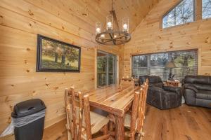a dining room with a wooden table in a cabin at Bessy Bears Cabin by American Patriot Getaways in Glade