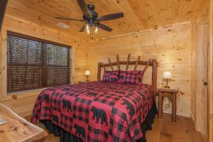 a bedroom with a bed and a ceiling fan at Bessy Bears Cabin by American Patriot Getaways in Glade