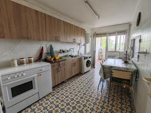 a kitchen with a stove and a table in it at El Monfortino Ribeira Sacra in Monforte de Lemos