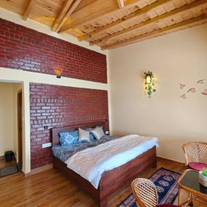 a bedroom with a brick wall and a bed at Meru Stays - A Kumaouni Homestay in Mukteshwar +24 photos