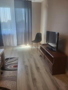 a living room with a tv and a chair at Panorama in Dzierżoniów