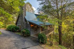 a stone house with a green roof in the woods at Old Glory by American Patriot Getaways in Catlettsburg