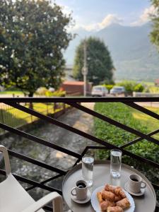 een tafel met een bord eten en twee glazen water bij Il cuore della valtellina in Caiolo