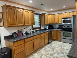 a kitchen with wooden cabinets and a sink at Ole Bud Cabin by American Patriot Getaways in Walnut Grove