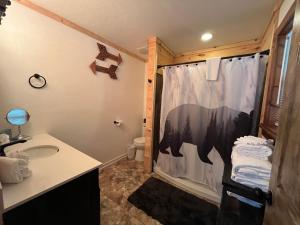 a bathroom with a shower with a bear shower curtain at Ole Bud Cabin by American Patriot Getaways in Walnut Grove +45 photos