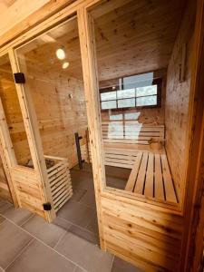 a wooden sauna with a bench in the middle at SEPPKEUSCHE - historisches Chalet mit Zirbensauna und Hotpot in Turracher Hohe