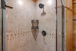 a bathroom with a shower with a glass door at Out on a Limb by American Patriot Getaways in Shady Grove +27 photos